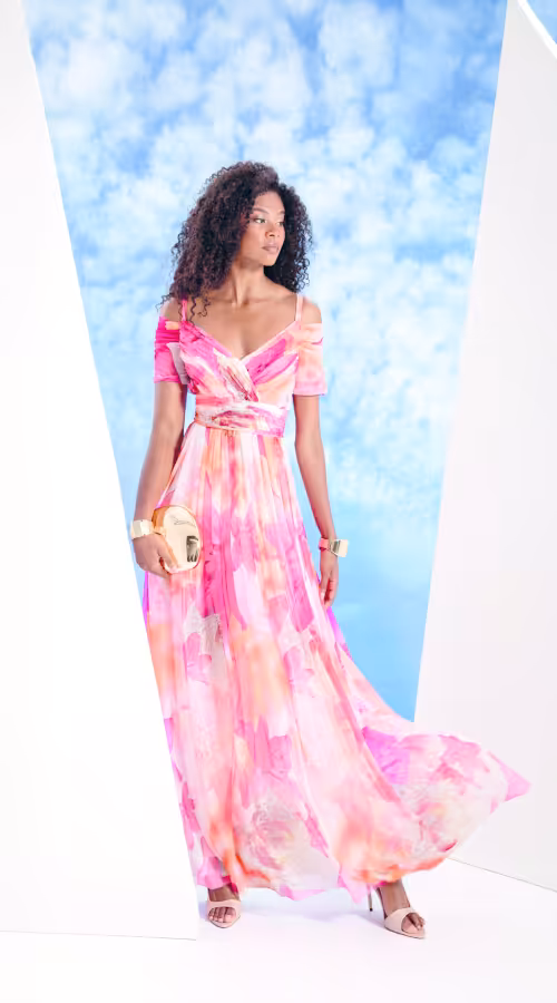 Abito da cerimonia lungo con fantasia floreale nei toni del rosa, scollatura off shoulder e gonna fluida disponibile da W le Donne Atelier Cerimonia.